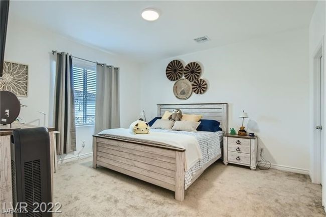 Bedroom with visible vents, light carpet, and baseboards | Image 7