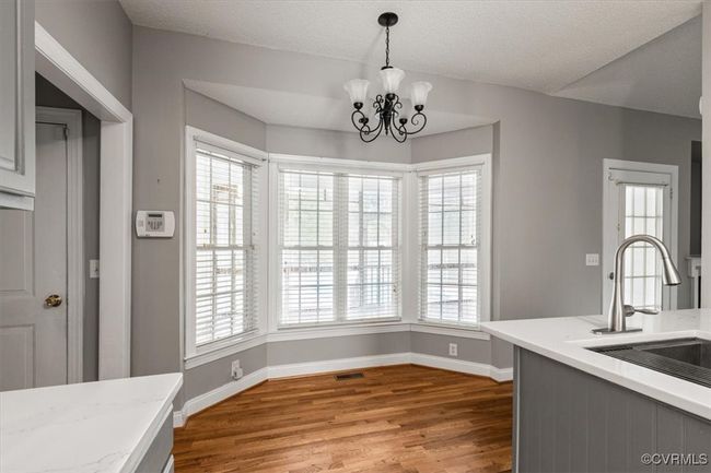 Unfurnished dining area featuring a sink, wood finished floors, baseboards, and plenty of natural light | Image 18