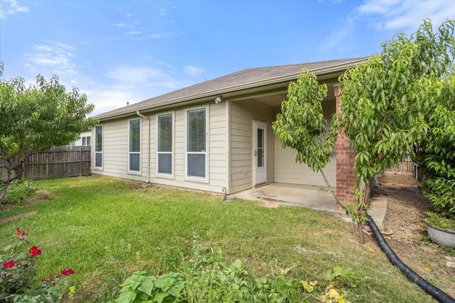 Rear view of house with a nice patio area to enjoy the view of the garden and fruit trees | Image 19