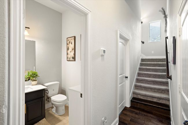 Half bathroom featuring baseboards, vanity, toilet, and wood finished floors | Image 22
