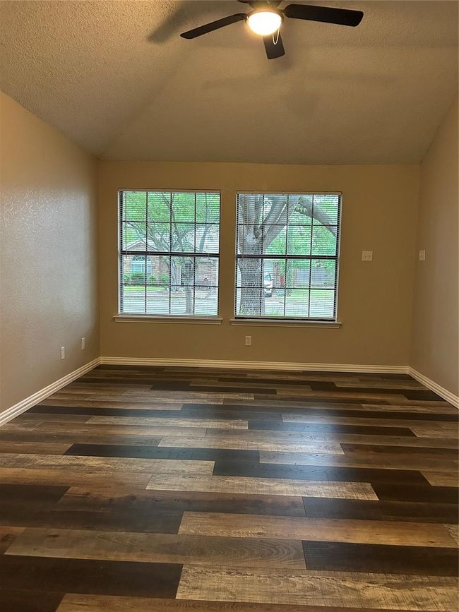 Unfurnished room featuring lofted ceiling, plenty of natural light, dark wood-type flooring, a ceiling fan, and a textured ceiling | Image 18