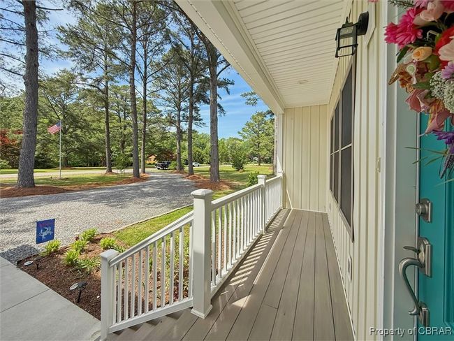 Deck featuring covered porch and view of scattered trees | Image 7