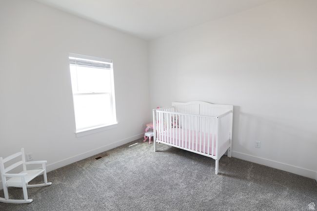 Bedroom with visible vents, baseboards, a nursery area, and carpet floors | Image 21