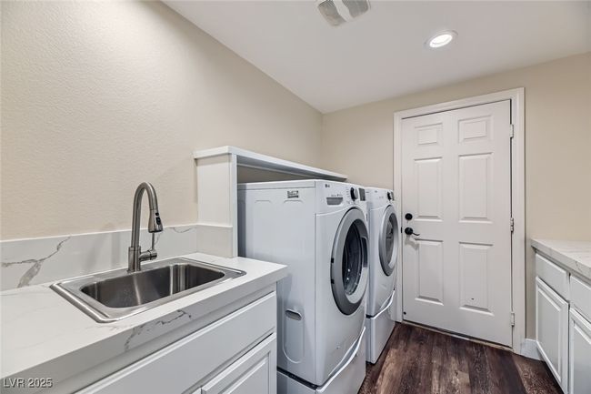 Laundry room with separate washer and dryer, dark wood-style floors, recessed lighting, and cabinet space | Image 37