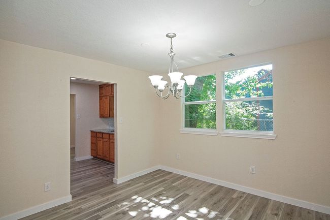 Unfurnished dining room with a chandelier and light wood-style flooring | Image 9
