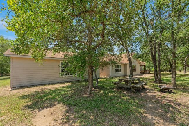 Great picnic area at the front of the house shaded by mature trees. | Image 7