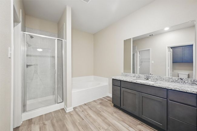 Bathroom featuring vanity, a shower stall, visible vents, a garden tub, and wood finished floors | Image 16