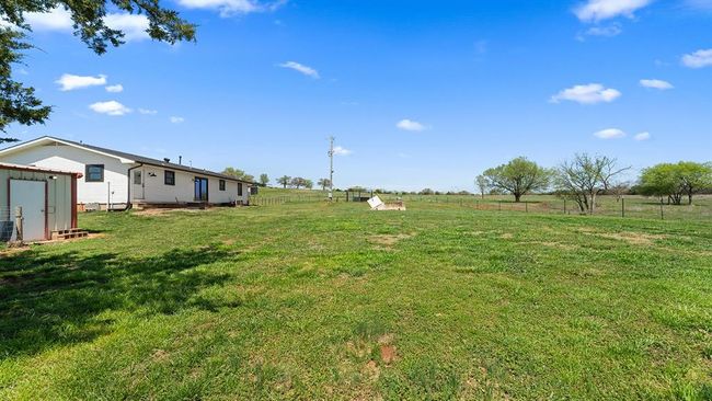 View of yard with a shed, a rural view, fence, and an outbuilding | Image 14