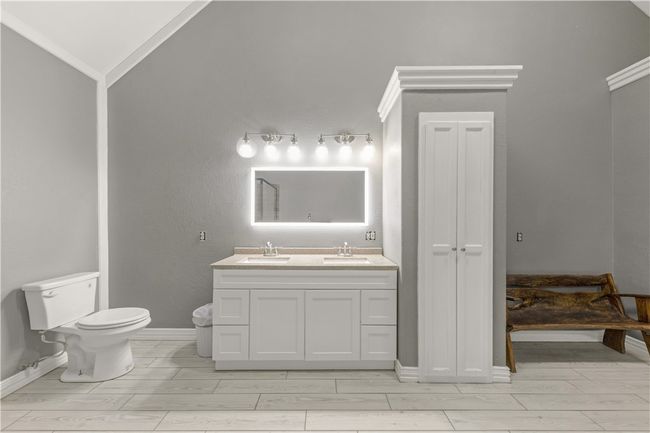 Full bathroom with double vanity, vaulted ceiling, ornamental molding, and tiled floors | Image 25