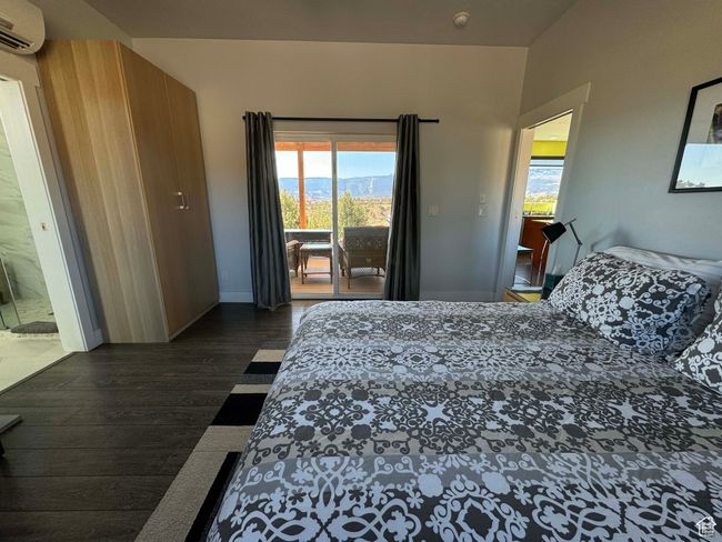 Bedroom featuring an AC wall unit, access to exterior in one of the rentals | Image 10