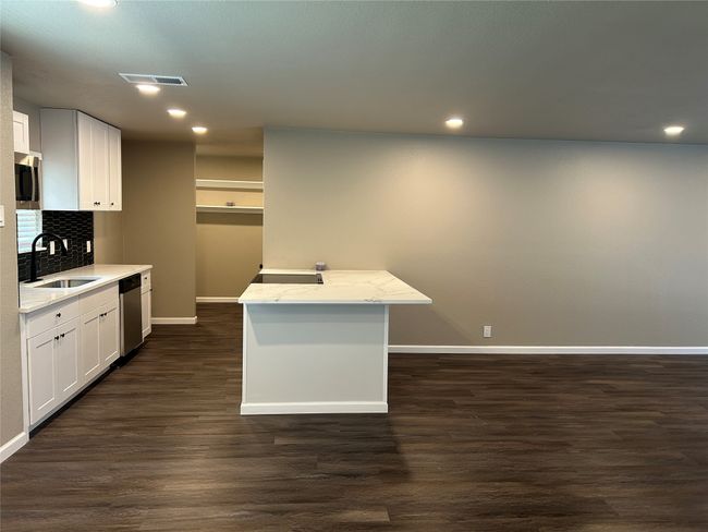 Kitchen featuring a sink, baseboards, stainless steel appliances, decorative backsplash, and dark wood-style floors | Image 20