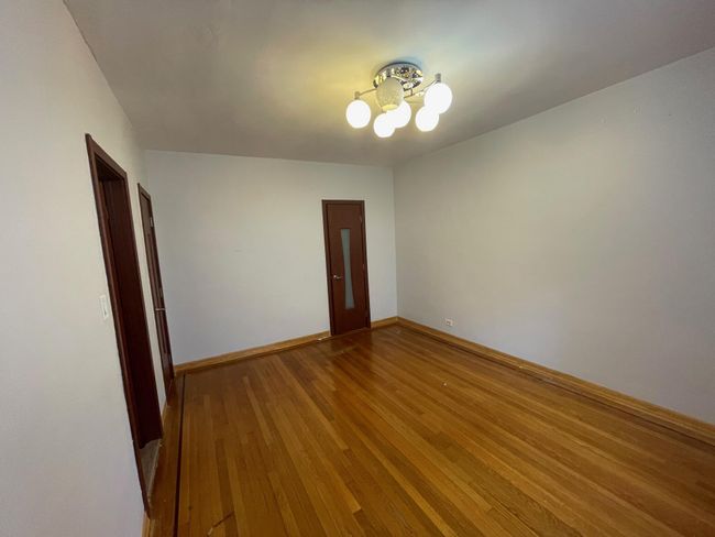 Unfurnished room with a chandelier, wood finished floors, and baseboards | Image 12