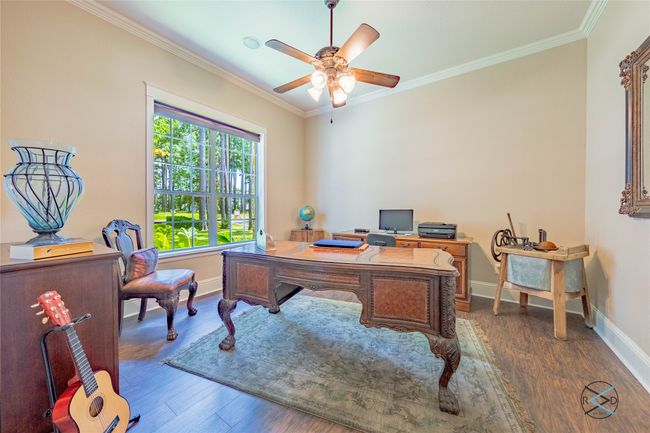 Office space with crown molding, dark wood-type flooring, and ceiling fan | Image 25