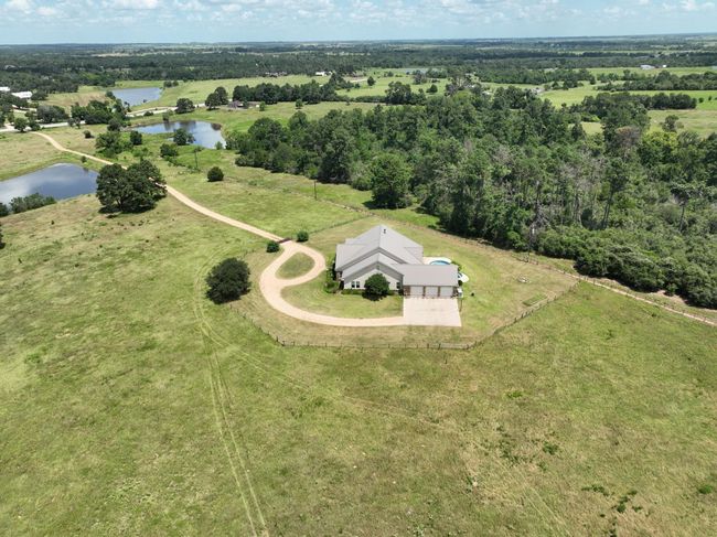 This aerial view showcases a spacious home with 3 car garage. | Image 49