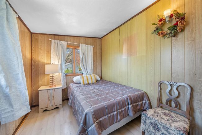 Bedroom featuring wooden walls and wood finished floors | Image 19