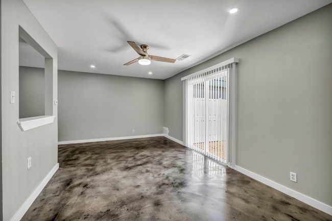 Spare room featuring finished concrete flooring, ceiling fan, baseboards, and recessed lighting | Image 7
