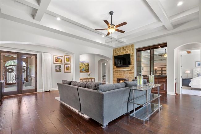 Living room featuring a ceiling fan, arched walkways, coffered ceiling, baseboards, and recessed lighting | Image 6