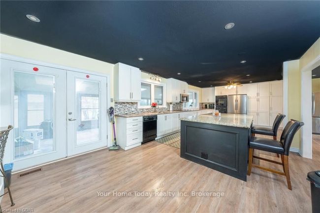 Kitchen featuring light wood-type flooring, white cabinetry, appliances with stainless steel finishes, and french doors | Image 14