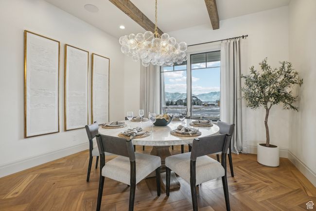 Dining area featuring a notable chandelier, baseboards, a mountain view, and beam ceiling | Image 10