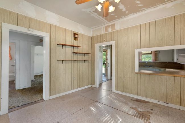 Empty room with wooden walls, baseboards, and ceiling fan | Image 18
