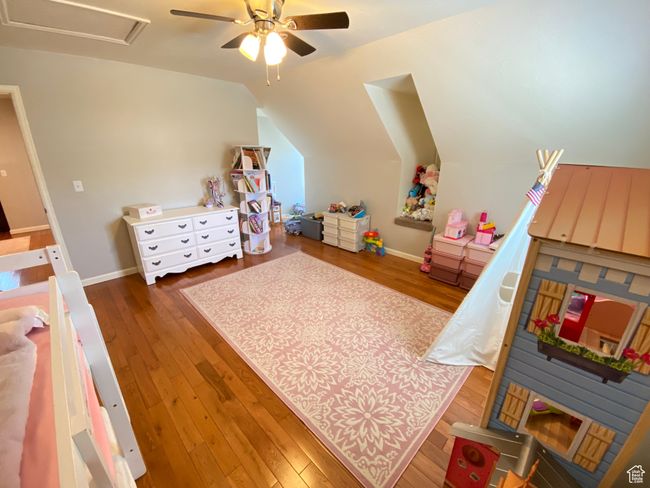 Bedroom featuring wood finished floors, lofted ceiling, ceiling fan, and baseboards | Image 18