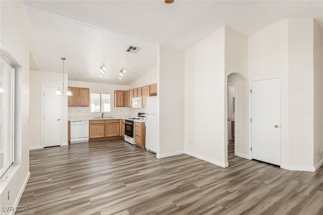 open kitchen and living area with vaulted ceilings | Image 7
