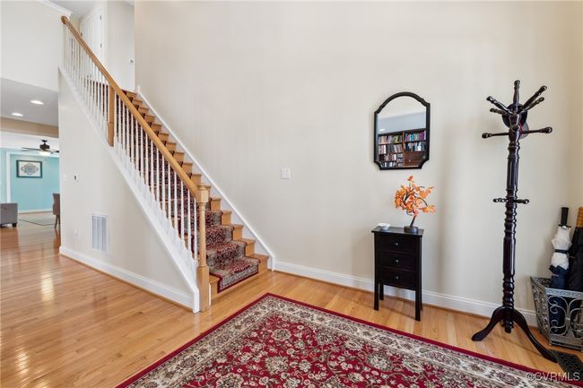 Back at the entry. Hardwood stairs with carpet runner and painted white balusters lead to the 2nd floor loft. | Image 33