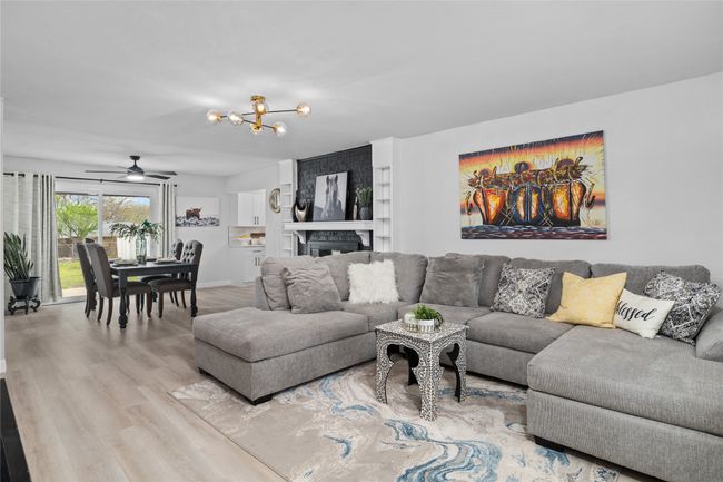 Living area with a chandelier and wood finished floors | Image 6