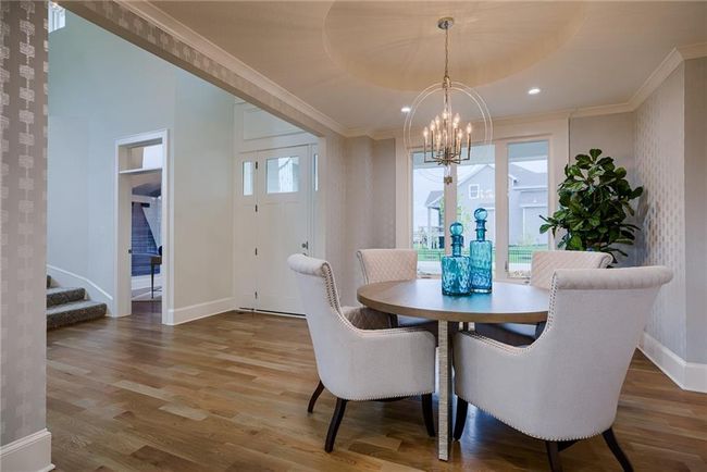 Dining area featuring hardwood / wood-style floors, crown molding, and an inviting chandelier | Image 23
