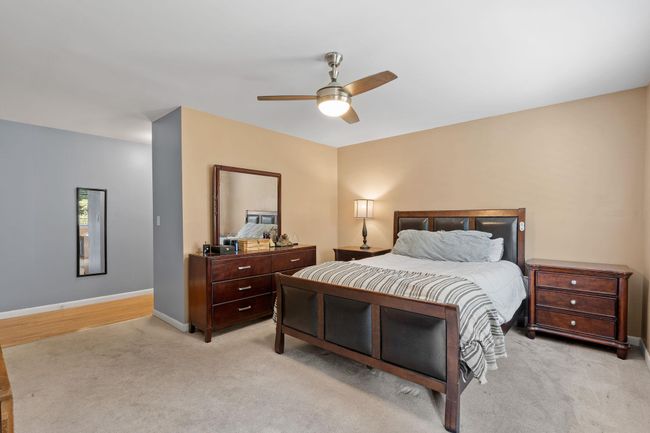 Bedroom with baseboards, ceiling fan, and light colored carpet | Image 7