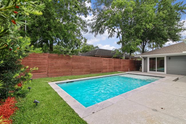 Relaxing is a breeze in this backyard. The pool features a sundeck and stone border. | Image 25