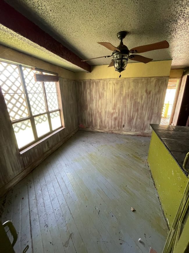 Unfurnished living room featuring a wealth of natural light, wooden walls, and light wood finished floors | Image 6