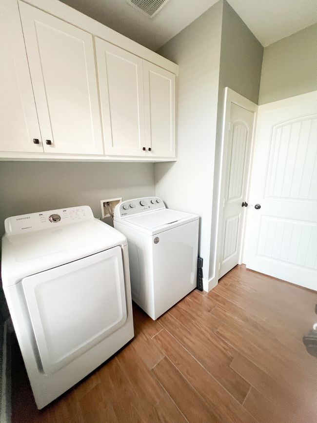 Clothes washing area featuring separate washer and dryer, cabinets, and light hardwood / wood-style flooring | Image 14