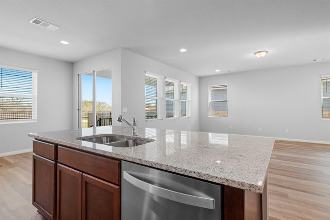 Kitchen with dishwasher, light wood finished floors, an island with sink, healthy amount of natural light, and recessed lighting | Image 12