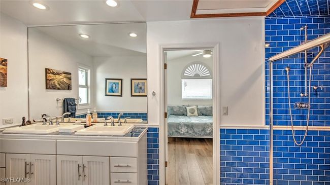Guest bathroom upstairs with wood finished floors, Jill and Jack bathroom, double vanity, healthy amount of natural light, and recessed lighting | Image 26