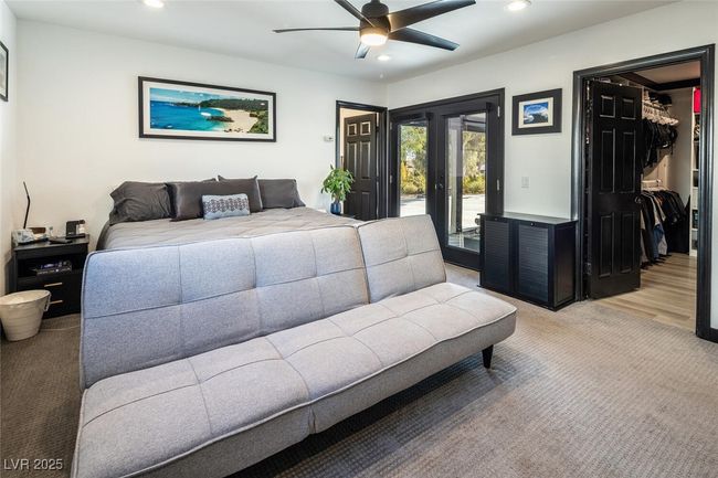Bedroom featuring access to exterior, recessed lighting, light colored carpet, and a walk in closet | Image 19