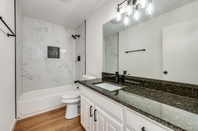 Bathroom with washtub / shower combination, toilet, vanity, and wood finished floors | Image 23