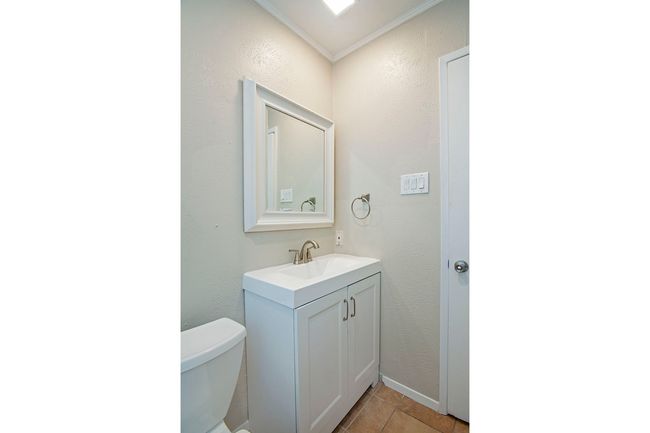 Bathroom with large vanity, crown molding, toilet, and tile flooring | Image 26