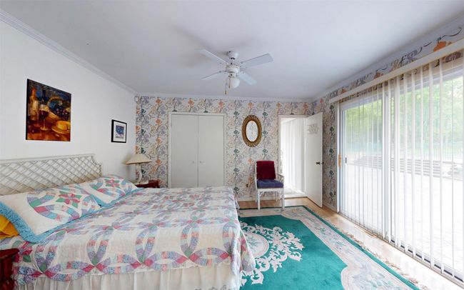 Bedroom with access to outside, crown molding, wood finished floors, a ceiling fan, and a closet | Image 35