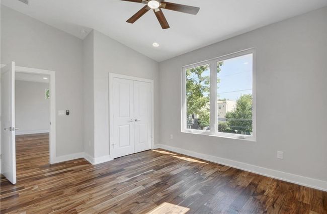 Unfurnished bedroom featuring a ceiling fan, baseboards, wood finished floors, lofted ceiling, and a closet | Image 23