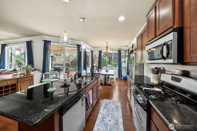 So many windows! Stainless steel appliances, granite countertops, under mount sink, gas stove-what's not to love? | Image 8