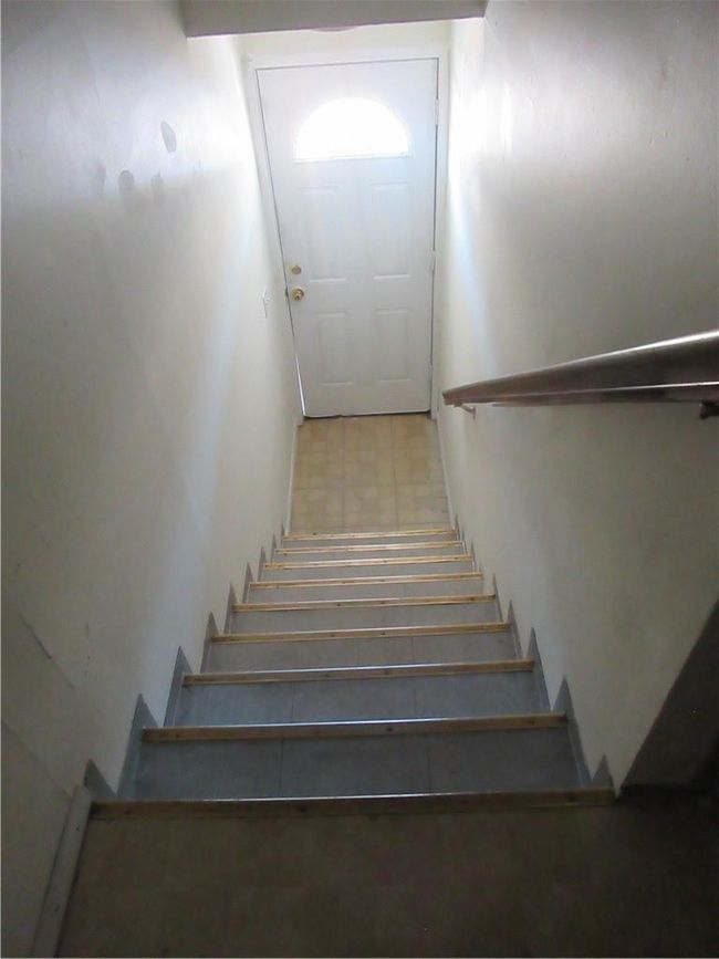View looking down stairs to apartment & door | Image 18