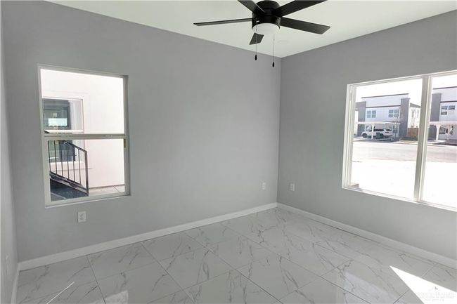 Empty room with marble finish floor, baseboards, ceiling fan, and a wealth of natural light | Image 12