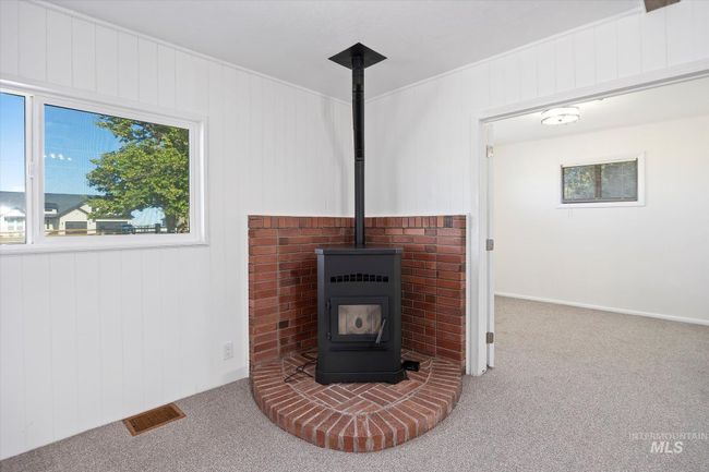 Detailed view of carpet, a wood stove, and wooden walls | Image 10