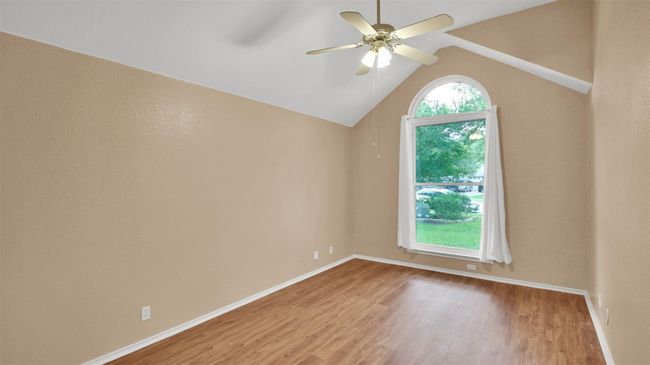 Guest bedroom featuring vinyl plank flooring, a ceiling fan, and vaulted ceiling | Image 22