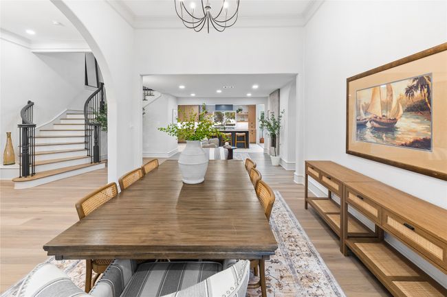 Dining area featuring light wood-style flooring, stairs, arched walkways, a chandelier, and recessed lighting | Image 9