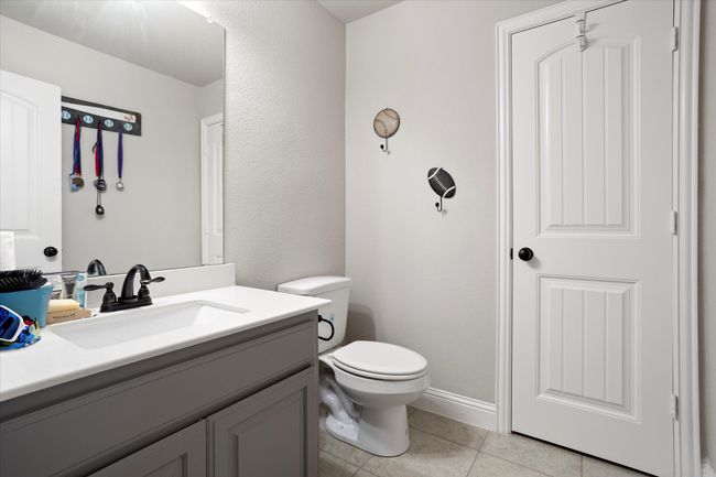 Half bathroom with toilet, tile patterned flooring, and vanity | Image 28