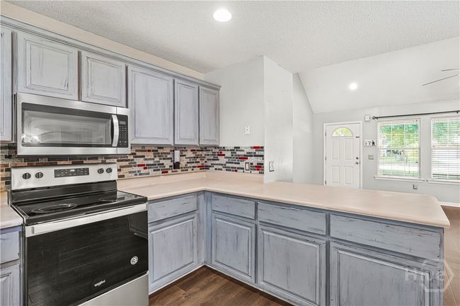 Kitchen provides an over-hang bar. Perfect to add stools for more seating area! | Image 12