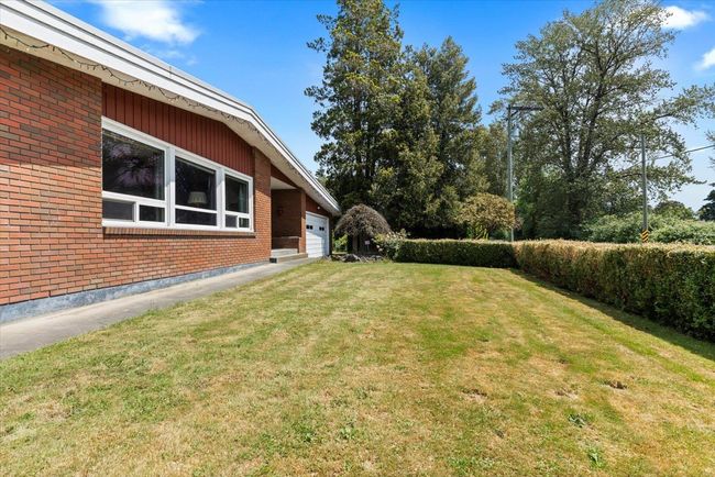 View of green lawn featuring a garage | Image 5