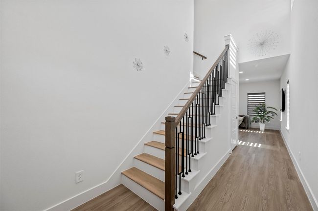 Staircase with wood finished floors and a high ceiling | Image 4